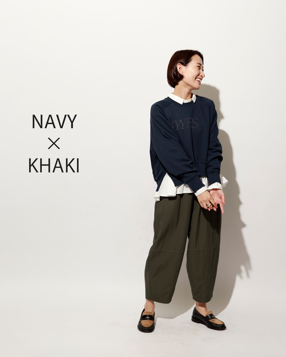 ネイビースウェット×カーキパンツに白ブラウスをレイヤードして、抜け感のある大人スタイルに
